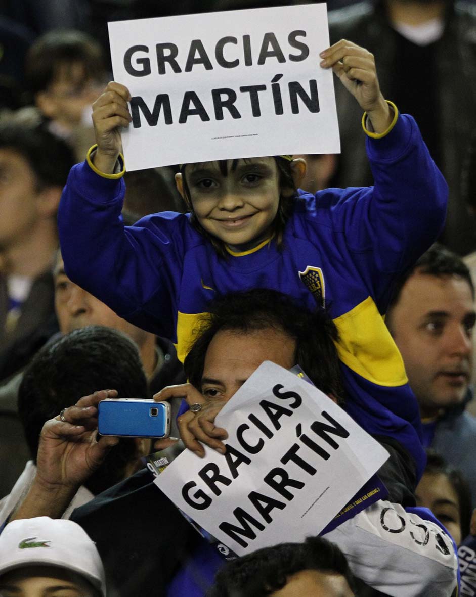 Fans hold signs of thanks for Boca Juniors' player Martin Palermo at his last match in "La Bombonera" stadium before retiring from the professional activity, at an Argentine league soccer match with with Banfield in Buenos Aires, Argentina, Sunday June 12, 2011. (AP Photo/Eduardo Di Baia)